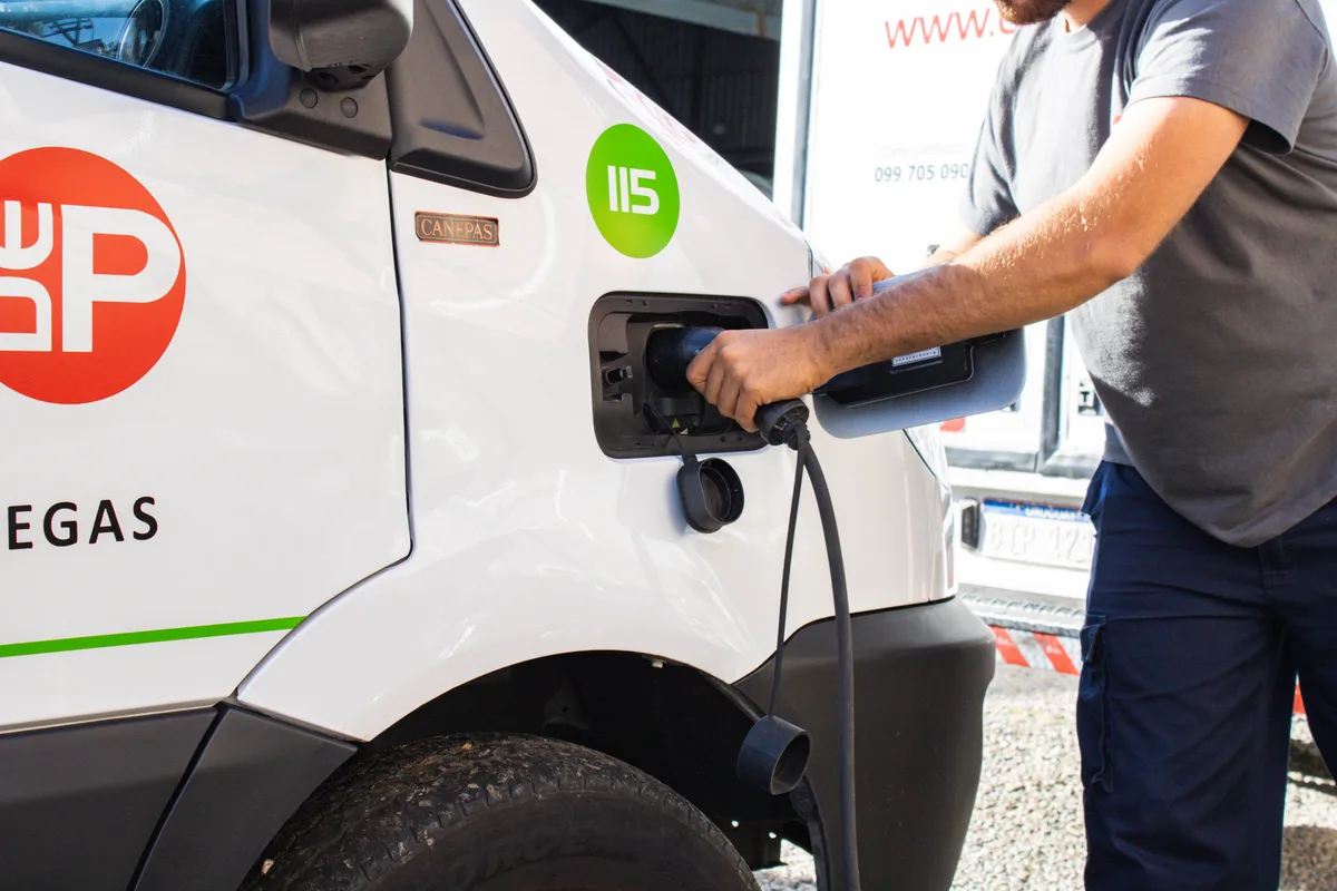 Integrante de DePunta conecta un vehículo eléctrico al cargador